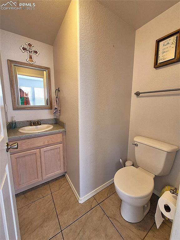 707 Valley View Dr, Woodland Park, CO 80863 - half bathroom featuring vanity, tile patterned flooring, toilet, and baseboards