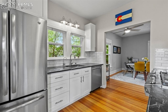 421 N Spruce St, Colorado Springs, CO 80905 - kitchen featuring stainless steel appliances, a sink, white cabinetry, backsplash, and light wood-style flooring