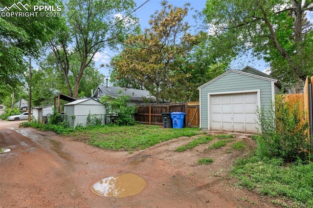 421 N Spruce St, Colorado Springs, CO 80905 - view of yard with a detached garage, dirt driveway, and an outbuilding