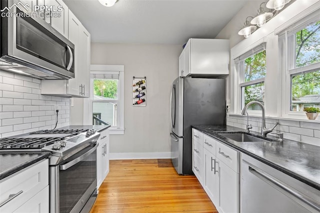 421 N Spruce St, Colorado Springs, CO 80905 - kitchen featuring appliances with stainless steel finishes, a sink, dark countertops, light wood-style floors, and healthy amount of natural light