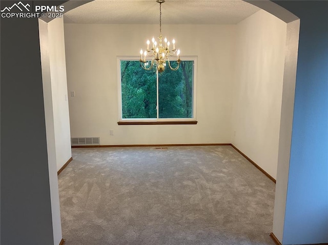 1185 Marlstone Pl, Colorado Springs, CO 80904 - carpeted empty room featuring a chandelier and arched walkways