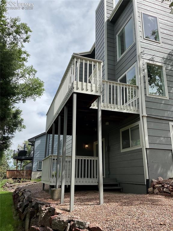 1185 Marlstone Pl, Colorado Springs, CO 80904 - view of property exterior featuring a deck and a chimney