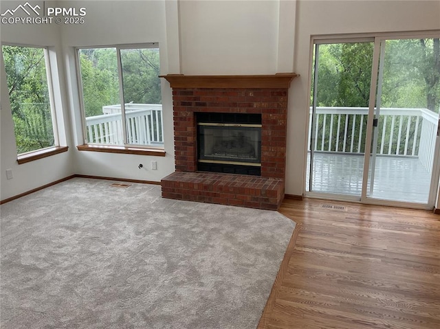 1185 Marlstone Pl, Colorado Springs, CO 80904 - unfurnished living room with healthy amount of natural light, a fireplace, wood finished floors, and carpet flooring