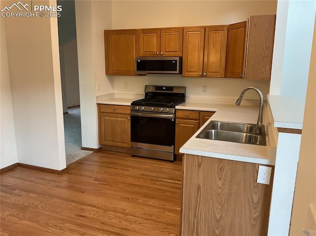 1185 Marlstone Pl, Colorado Springs, CO 80904 - kitchen with stainless steel appliances, light wood-type flooring, brown cabinets, and light countertops