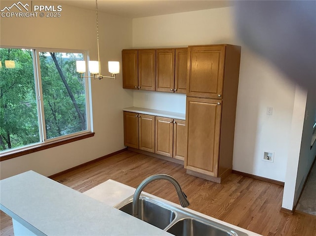 1185 Marlstone Pl, Colorado Springs, CO 80904 - kitchen featuring a chandelier, light wood-style floors, brown cabinets, and plenty of natural light