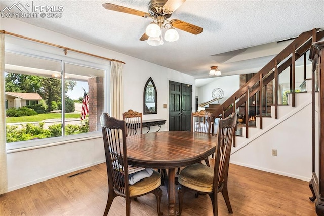 965 Red Mesa Dr, Colorado Springs, CO 80906 - dining area featuring stairs, a textured ceiling, light wood finished floors, and a ceiling fan