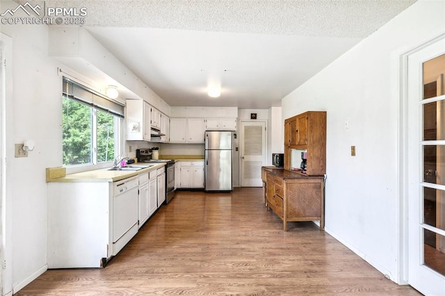 965 Red Mesa Dr, Colorado Springs, CO 80906 - kitchen featuring appliances with stainless steel finishes, light wood-style flooring, white cabinetry, light countertops, and under cabinet range hood
