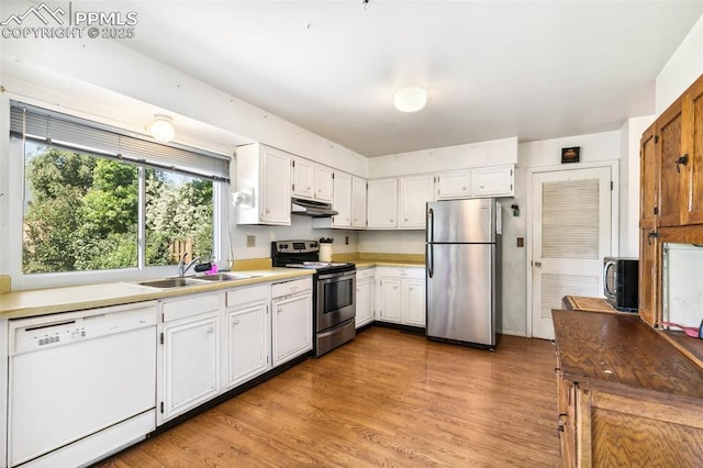 965 Red Mesa Dr, Colorado Springs, CO 80906 - kitchen featuring appliances with stainless steel finishes, under cabinet range hood, wood finished floors, light countertops, and white cabinets