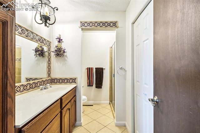 965 Red Mesa Dr, Colorado Springs, CO 80906 - bathroom with vanity, tile patterned flooring, a shower with door, a textured ceiling, and a closet