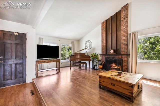 965 Red Mesa Dr, Colorado Springs, CO 80906 - living room with vaulted ceiling, wood finished floors, and a brick fireplace