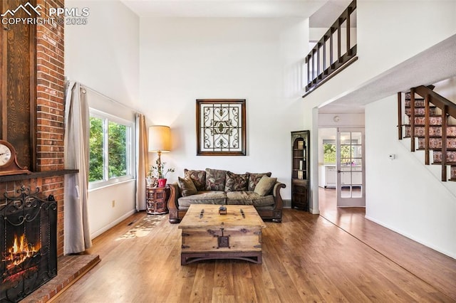 965 Red Mesa Dr, Colorado Springs, CO 80906 - living room with stairs, a towering ceiling, a brick fireplace, and wood finished floors
