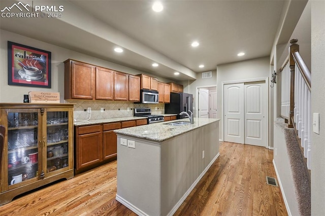 2374 Cinnabar Rd, Colorado Springs, CO 80921 - kitchen featuring appliances with stainless steel finishes, light wood-type flooring, brown cabinetry, recessed lighting, and decorative backsplash