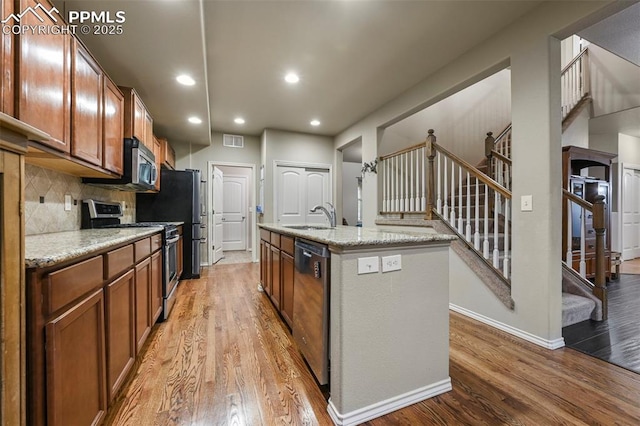 2374 Cinnabar Rd, Colorado Springs, CO 80921 - kitchen with appliances with stainless steel finishes, wood finished floors, brown cabinetry, backsplash, and recessed lighting