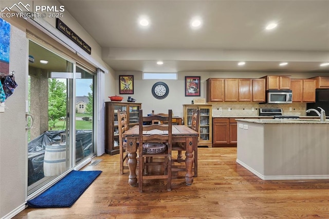 2374 Cinnabar Rd, Colorado Springs, CO 80921 - kitchen featuring stainless steel microwave, range, light wood-style floors, tasteful backsplash, and recessed lighting