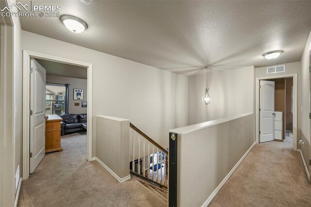 2374 Cinnabar Rd, Colorado Springs, CO 80921 - hallway featuring an upstairs landing, a textured ceiling, and carpet flooring