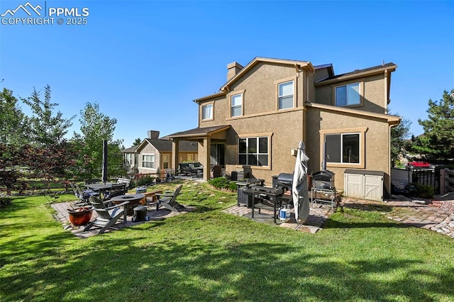 2374 Cinnabar Rd, Colorado Springs, CO 80921 - rear view of house featuring a patio area, stucco siding, a chimney, and a lawn