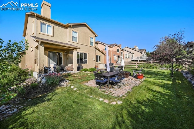 2374 Cinnabar Rd, Colorado Springs, CO 80921 - rear view of property featuring a chimney, a patio area, a yard, stucco siding, and a residential view