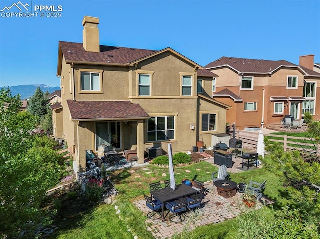 2374 Cinnabar Rd, Colorado Springs, CO 80921 - back of house with a chimney, stucco siding, a patio area, an outdoor living space with a fire pit, and a shingled roof
