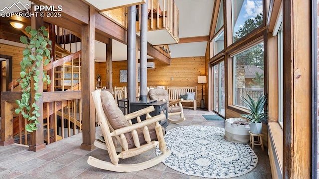 145 Valley Ln, Woodland Park, CO 80863 - living room featuring wooden walls, a high ceiling, and stone finish flooring