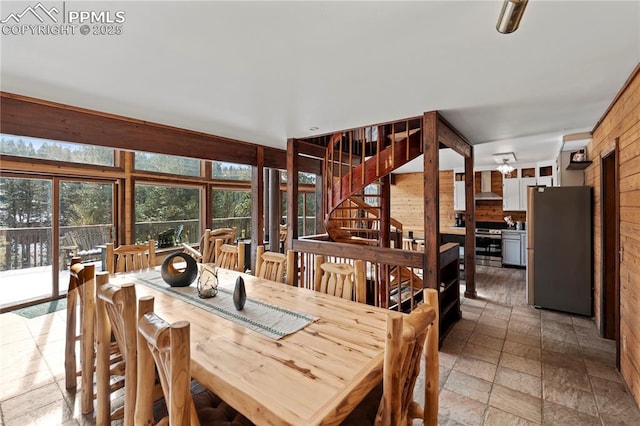 145 Valley Ln, Woodland Park, CO 80863 - dining space with wood walls, light stone finish floors, and stairs