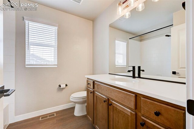 6967 Akela Ln, Colorado Springs, CO 80925 - bathroom with vanity, baseboards, toilet, wood finished floors, and bathtub / shower combination