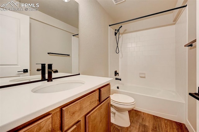 6967 Akela Ln, Colorado Springs, CO 80925 - bathroom featuring vanity, wood finished floors, toilet, and shower / tub combination