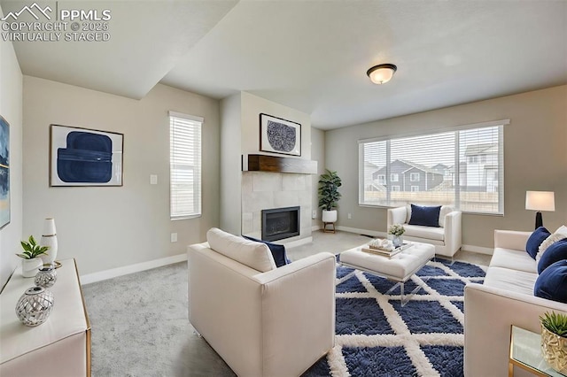 6967 Akela Ln, Colorado Springs, CO 80925 - carpeted living area with baseboards, plenty of natural light, and a tile fireplace