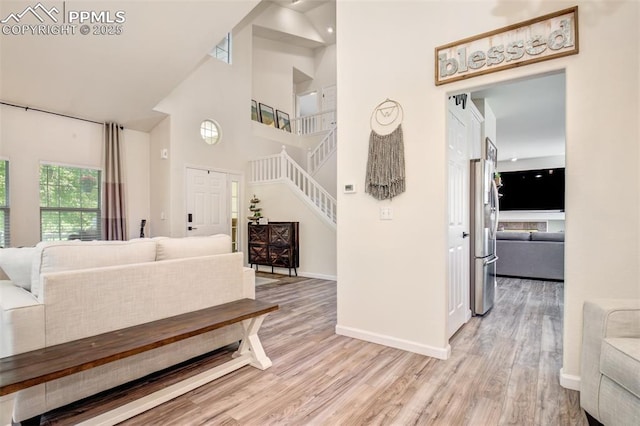 16084 Stonebriar Dr, Parker, CO 80134 - living area featuring a high ceiling, light wood-type flooring, baseboards, and stairway