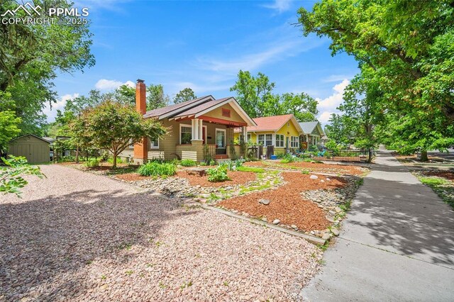 424 N Cedar St, Colorado Springs, CO 80903 - view of front facade featuring a chimney and covered porch