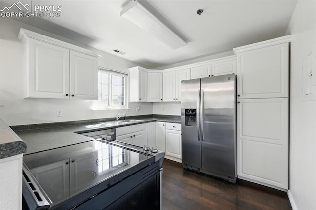 2150 Alicia Pt Unit 201, Colorado Springs, CO 80919 - kitchen featuring stainless steel refrigerator with ice dispenser, electric range oven, dark countertops, dark wood finished floors, and white cabinetry