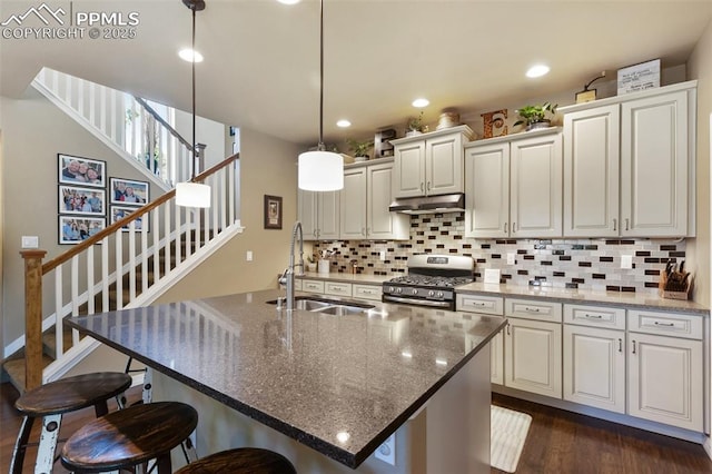1593 Gold Hill Mesa Dr, Colorado Springs, CO 80905 - kitchen with gas range, under cabinet range hood, dark wood finished floors, backsplash, and recessed lighting