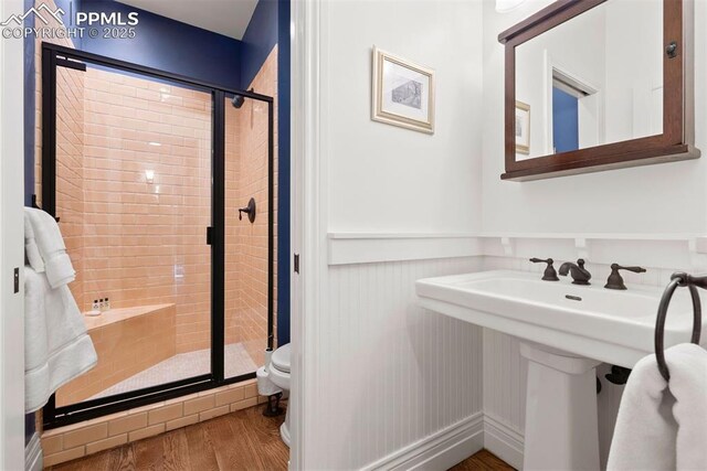 3 Mesa Ln, Colorado Springs, CO 80906 - bathroom with a wainscoted wall, a shower stall, and wood finished floors