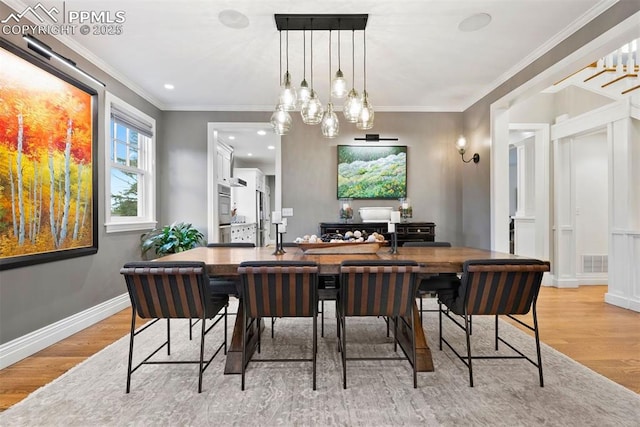 3 Mesa Ln, Colorado Springs, CO 80906 - dining area with light wood-type flooring, a chandelier, and ornamental molding