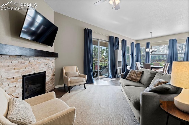 1734 Summerglow Ln, Monument, CO 80132 - living area with a chandelier, a ceiling fan, wood finished floors, and a stone fireplace