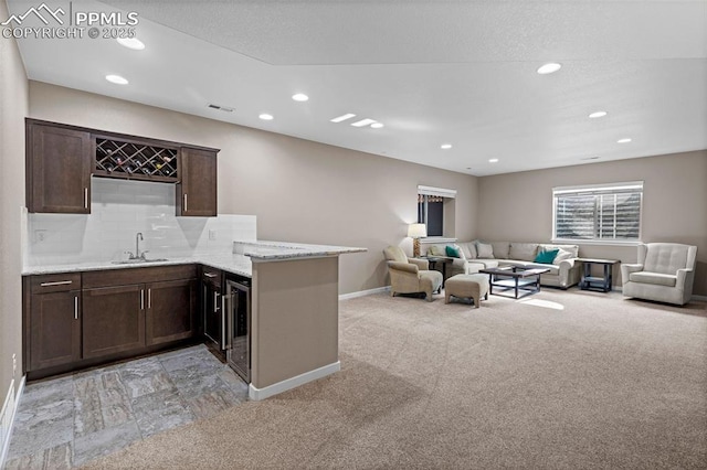 1734 Summerglow Ln, Monument, CO 80132 - kitchen featuring a sink, baseboards, recessed lighting, dark brown cabinets, and open floor plan