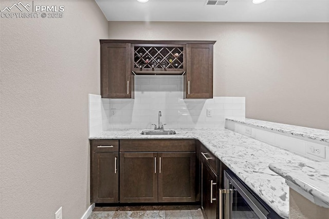 1734 Summerglow Ln, Monument, CO 80132 - kitchen with a sink, decorative backsplash, beverage cooler, and dark brown cabinetry