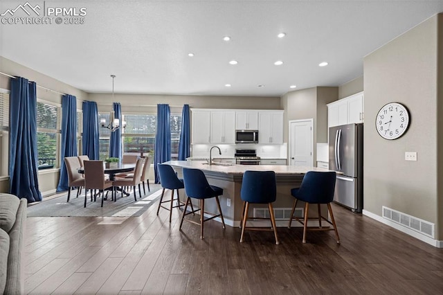 1734 Summerglow Ln, Monument, CO 80132 - kitchen with appliances with stainless steel finishes, recessed lighting, a sink, a large island with sink, and baseboards