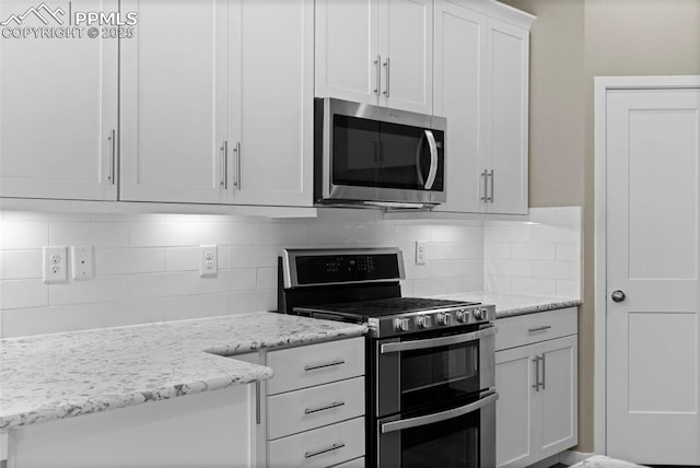 1734 Summerglow Ln, Monument, CO 80132 - kitchen with stainless steel appliances, tasteful backsplash, white cabinets, and light stone countertops