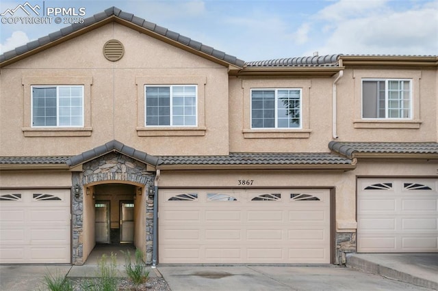 3867 Josephine Hts, Colorado Springs, CO 80906 - view of property with stone siding, a garage, a tile roof, stucco siding, and concrete driveway