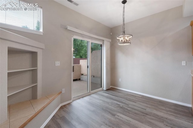 3867 Josephine Hts, Colorado Springs, CO 80906 - empty room featuring wood finished floors, built in features, and a chandelier
