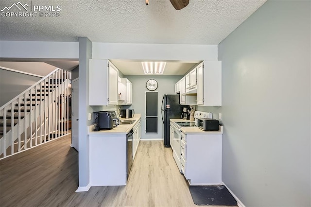 4652 Excalibur Ct, Colorado Springs, CO 80917 - kitchen with light wood-style flooring, white cabinetry, light countertops, white electric range, and under cabinet range hood