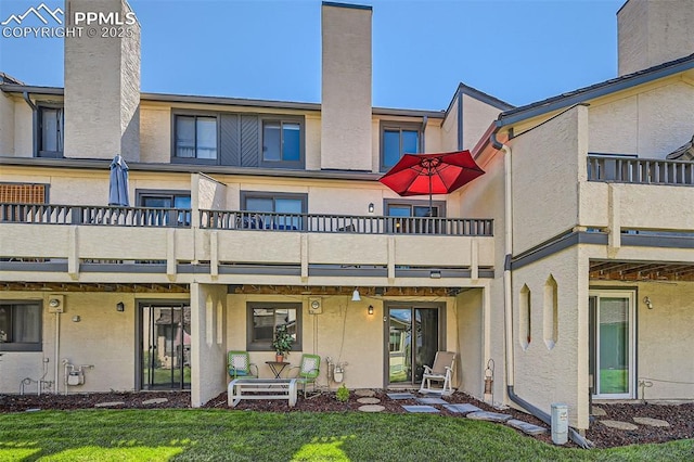 4652 Excalibur Ct, Colorado Springs, CO 80917 - back of property featuring a balcony, stucco siding, and a chimney