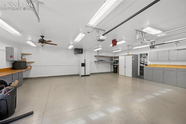 3512 Chico Cir, Colorado Springs, CO 80918 - garage with a garage door opener, white fridge with ice dispenser, and ceiling fan