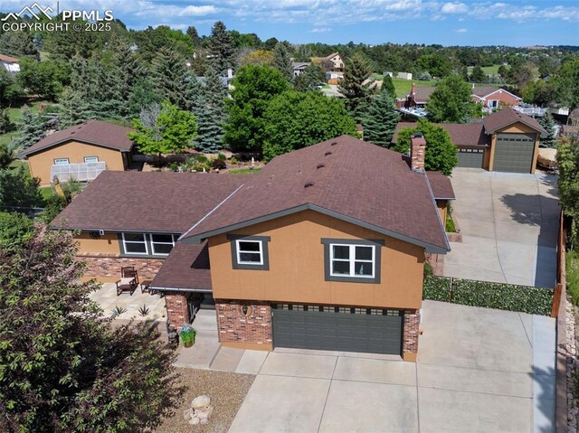 3512 Chico Cir, Colorado Springs, CO 80918 - view of front facade featuring brick siding, concrete driveway, a garage, and a shingled roof