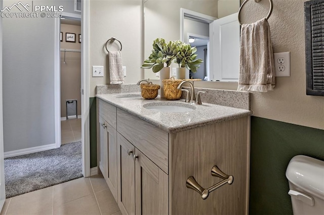 7703 Lost Trail Dr, Colorado Springs, CO 80908 - full bathroom featuring tile patterned flooring, double vanity, toilet, and baseboards