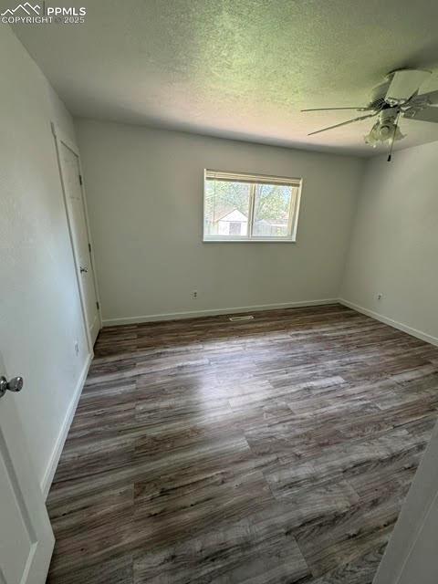 4425 Barkman Cir, Colorado Springs, CO 80916 - spare room featuring ceiling fan, dark wood-style flooring, baseboards, and a textured ceiling