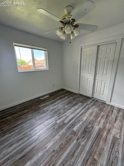 4425 Barkman Cir, Colorado Springs, CO 80916 - unfurnished bedroom with wood finished floors, a closet, baseboards, and ceiling fan