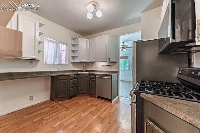 2830 W Kiowa St, Colorado Springs, CO 80904 - kitchen featuring stainless steel appliances, open shelves, light wood-style flooring, and ceiling fan