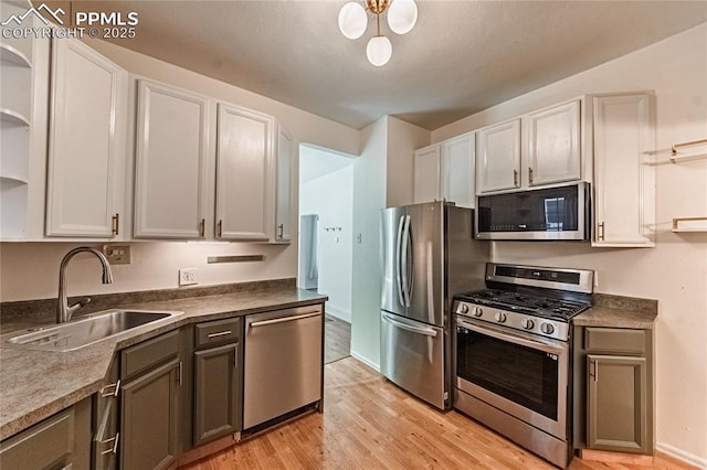2830 W Kiowa St, Colorado Springs, CO 80904 - kitchen featuring appliances with stainless steel finishes, open shelves, light wood-style flooring, and white cabinets