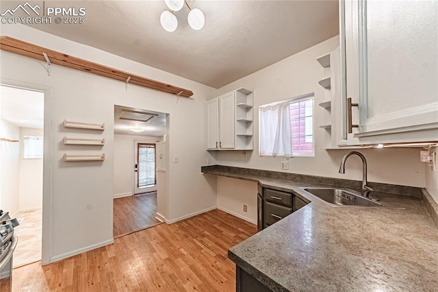 2830 W Kiowa St, Colorado Springs, CO 80904 - kitchen with open shelves, light wood-style floors, dark countertops, and white cabinets